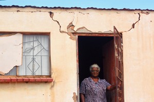 Photo of a woman in the doorway of her house