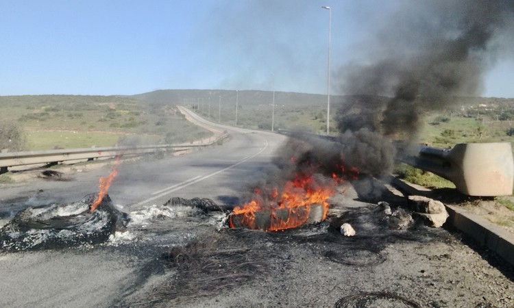 Photo of burning rubble across a road