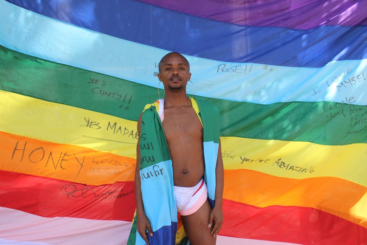 Photo of man dancing with rainbow flag