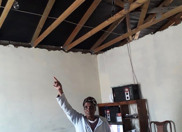 Photo of woman pointing to broken ceiling