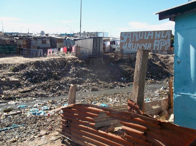 Photo of shacks and filthy water