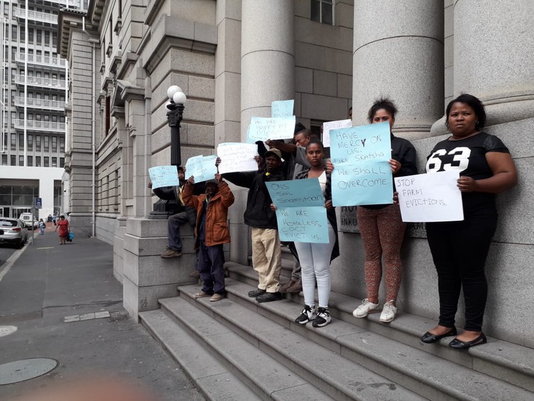 Photo of people with placards outside court