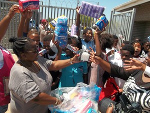 Photo of woman handing out sanitary pads to girls