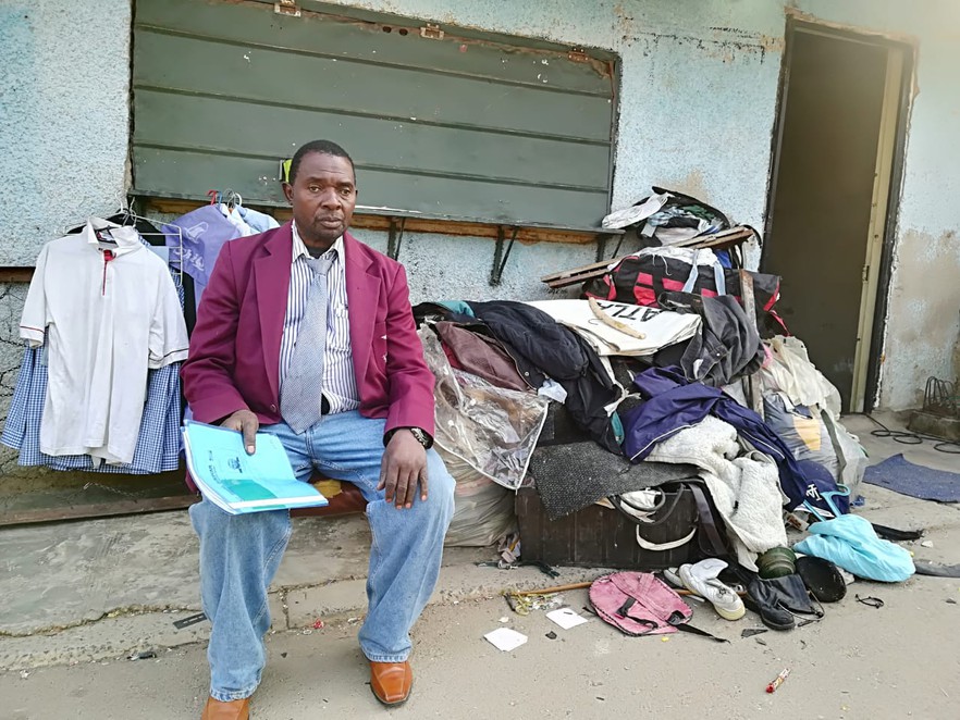 Photo of man with his belongings outside