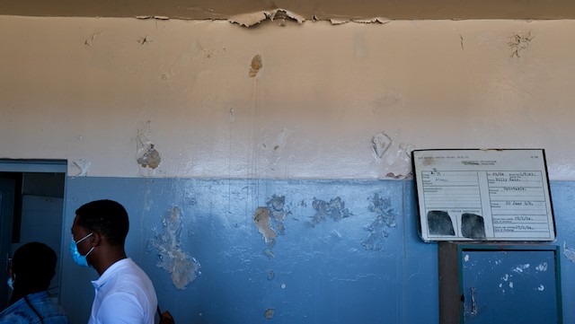 Peeling paint and water damage is visible on the prison’s interior walls.
