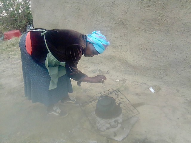 Photo of a woman at her cooking fire