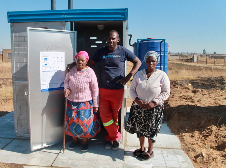 Photo of three people in front of a new toilet