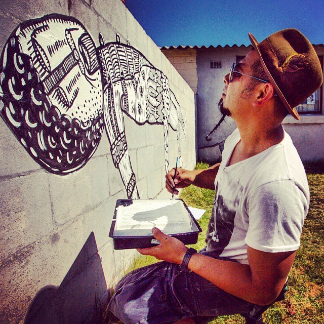 Photo of artist painting a mural