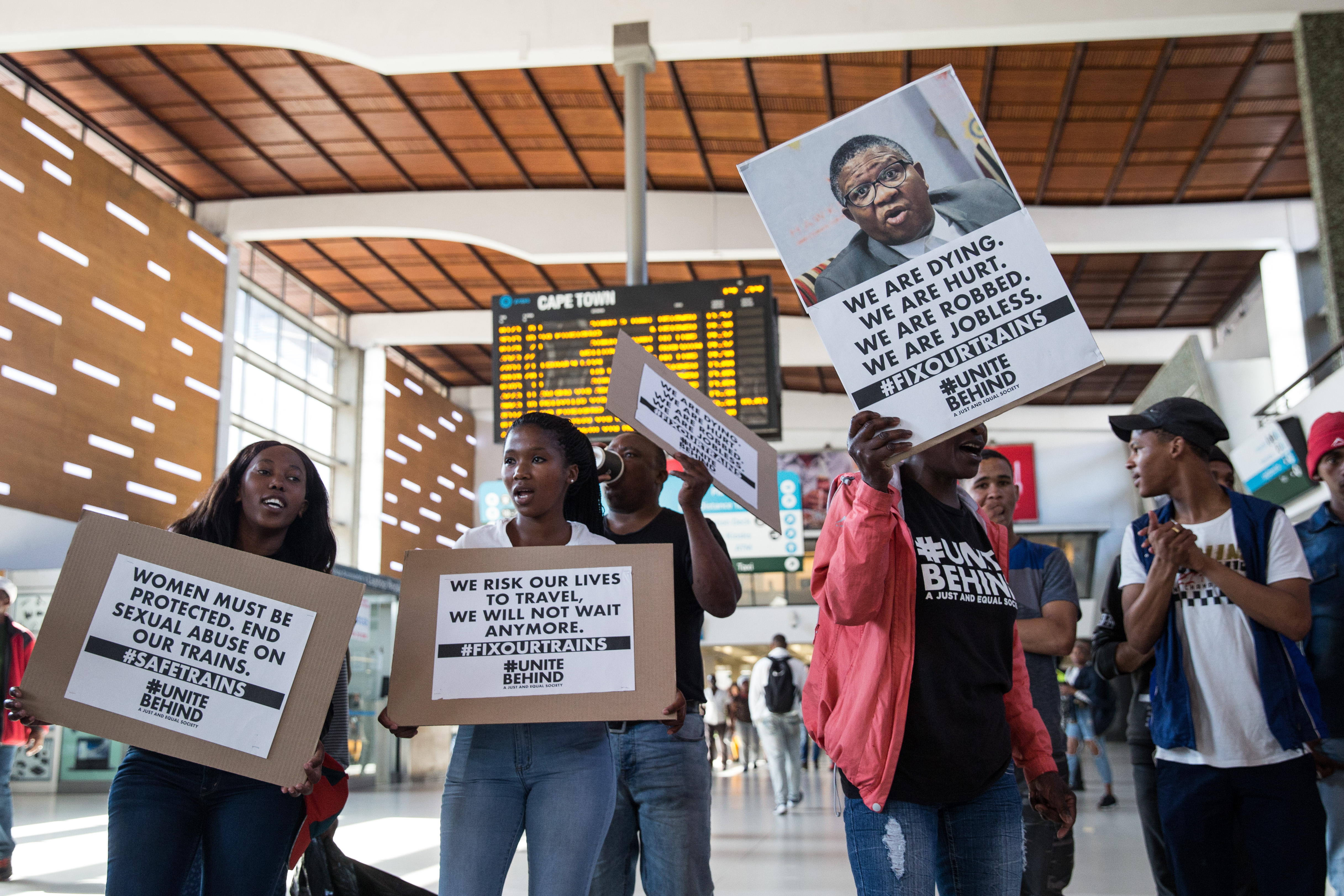 Photo of UniteBehind protesting at a train station with posters