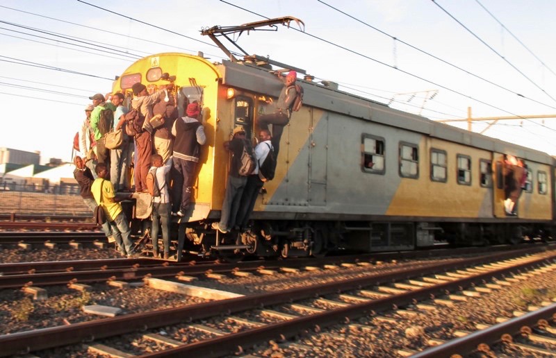 Photo of people hanging on to the back of a train