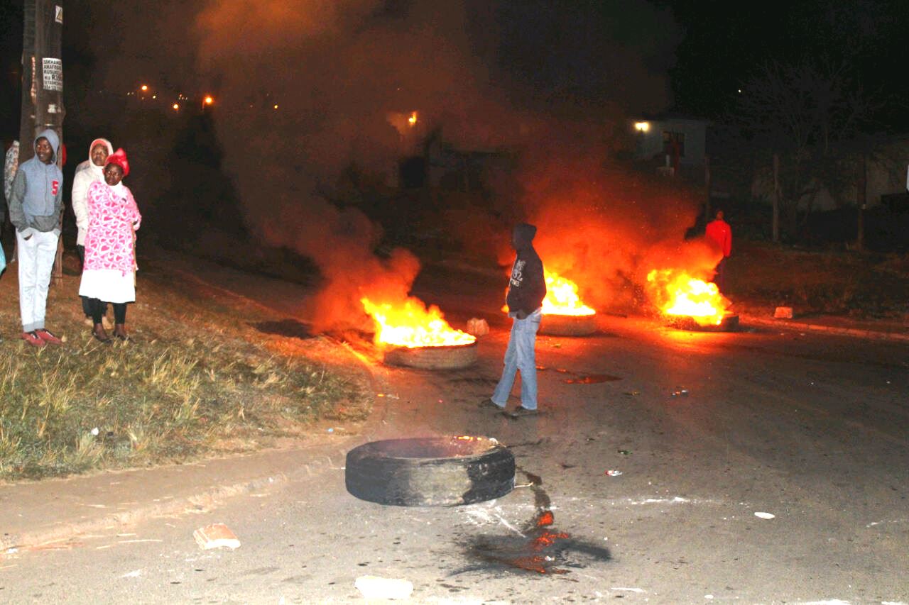 Photo of burning tyres and people standing around